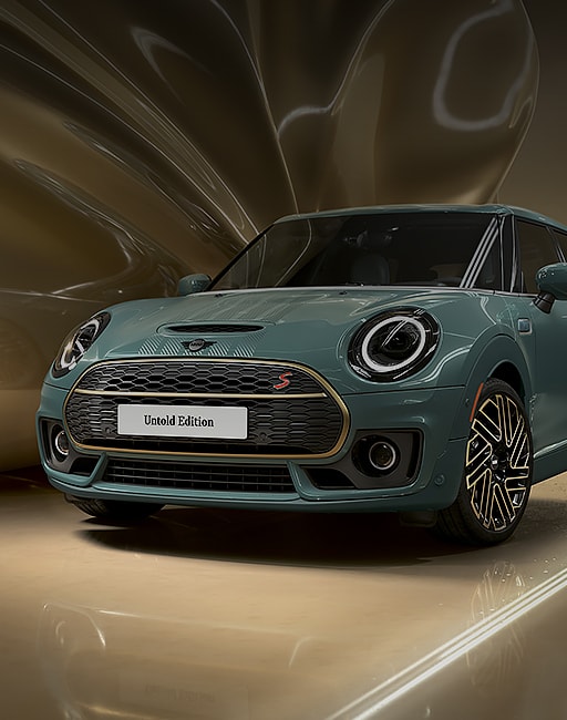 Three-quarters front view of a MINI Clubman Untold Edition, parked in a CGI world with shiny brass layers arched over the vehicle from behind.