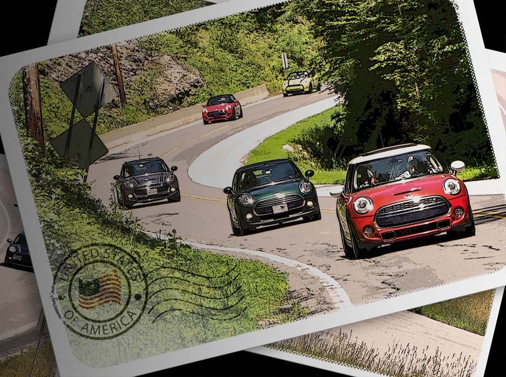 Postcard with an image of five MINI vehicles in different vehicle colors facing forward and driving in a row on an open road, with trees and shrubbery positioned on each side of the road plus a “United States of America” badge on the bottom-left corner of the postcard.
