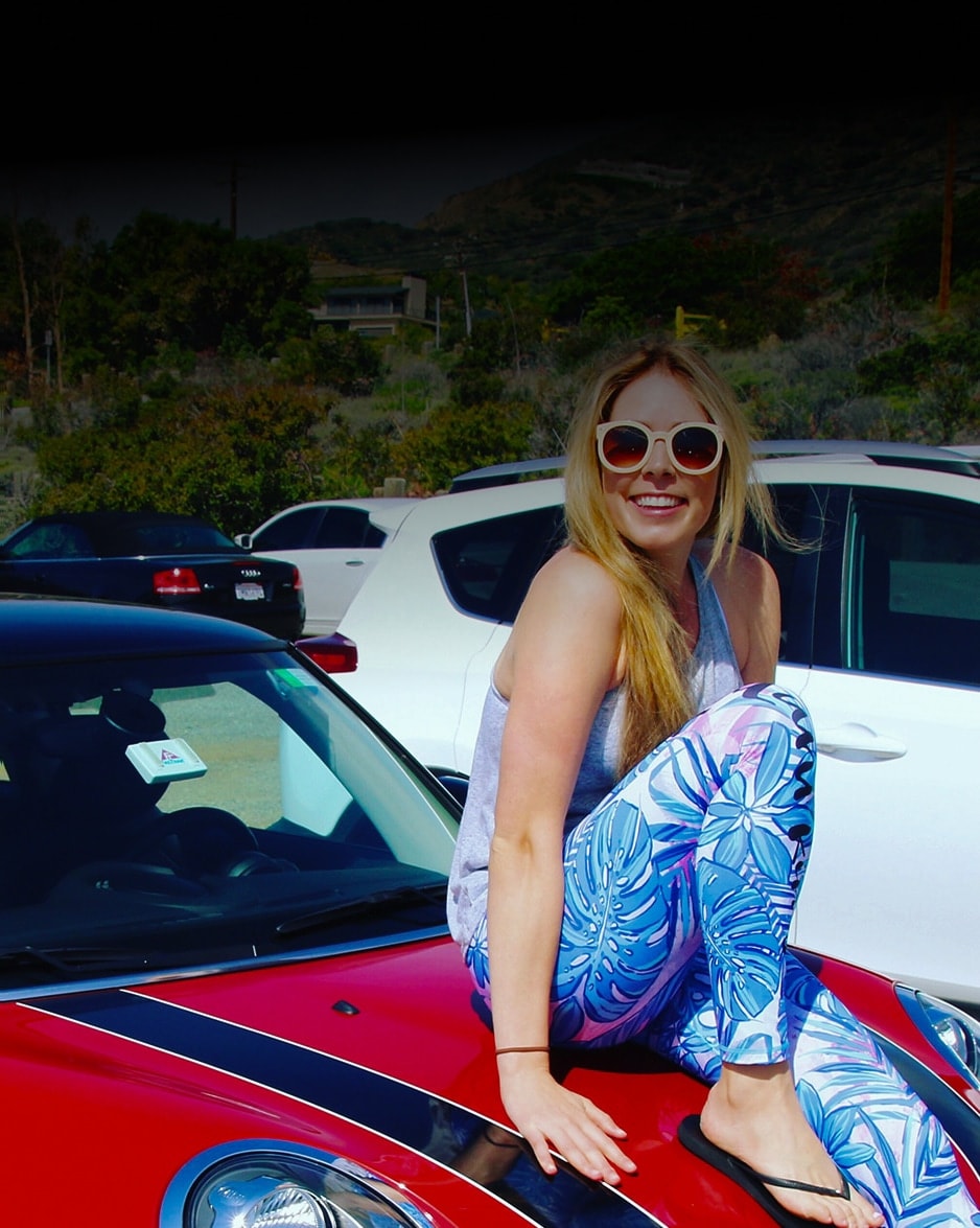 Dani Atkins and Alex holding up peace signs in front of a Kulani Swim pop up. 