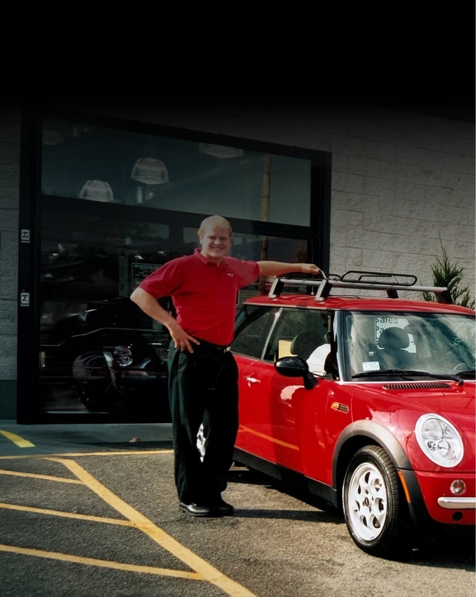 Brig Currie and a woman standing near one of the first MINI Cooper 2 Doors in the United States. 