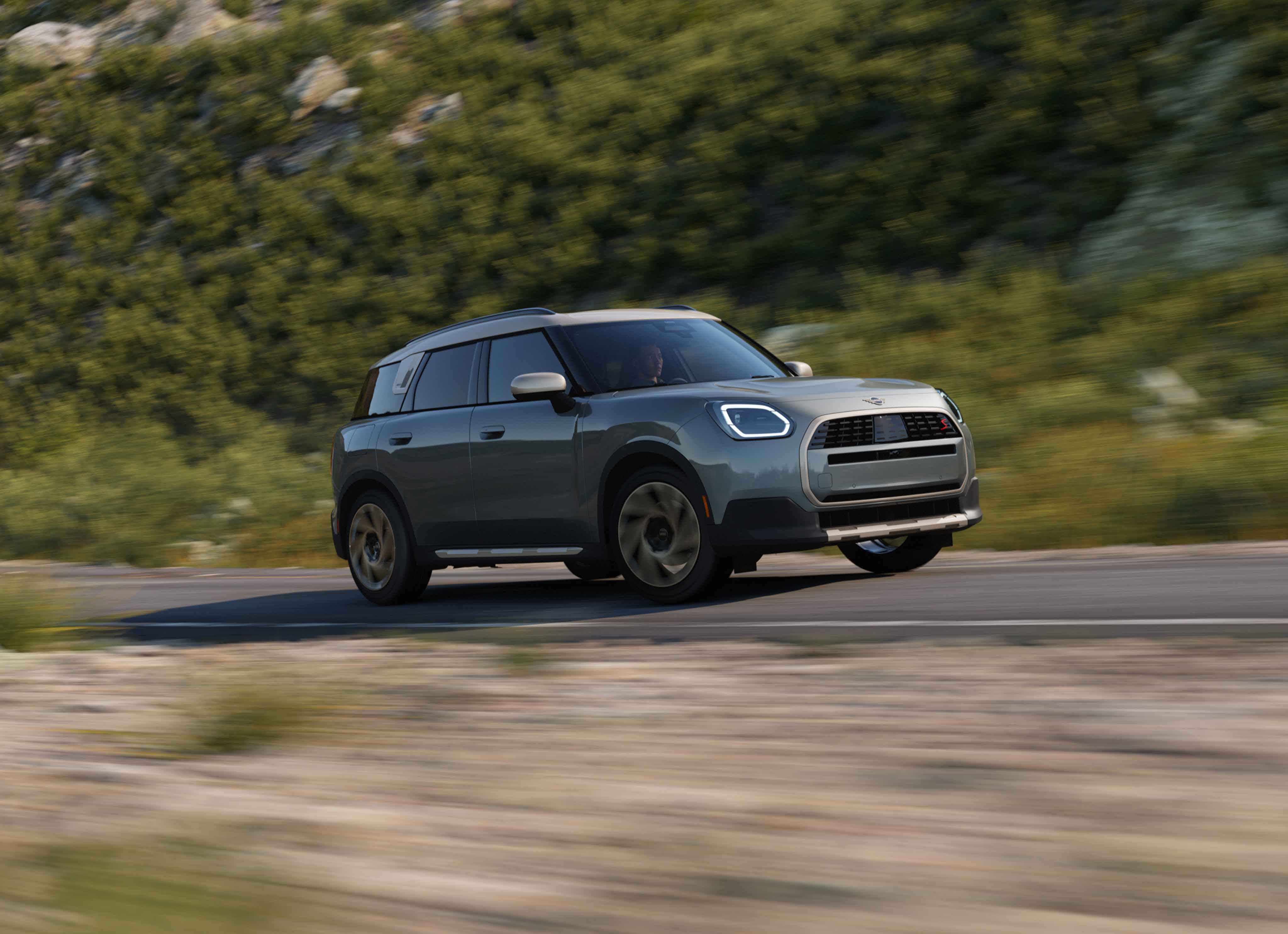 Angled view of a MINI Countryman S ALL4 driving in a lush region.