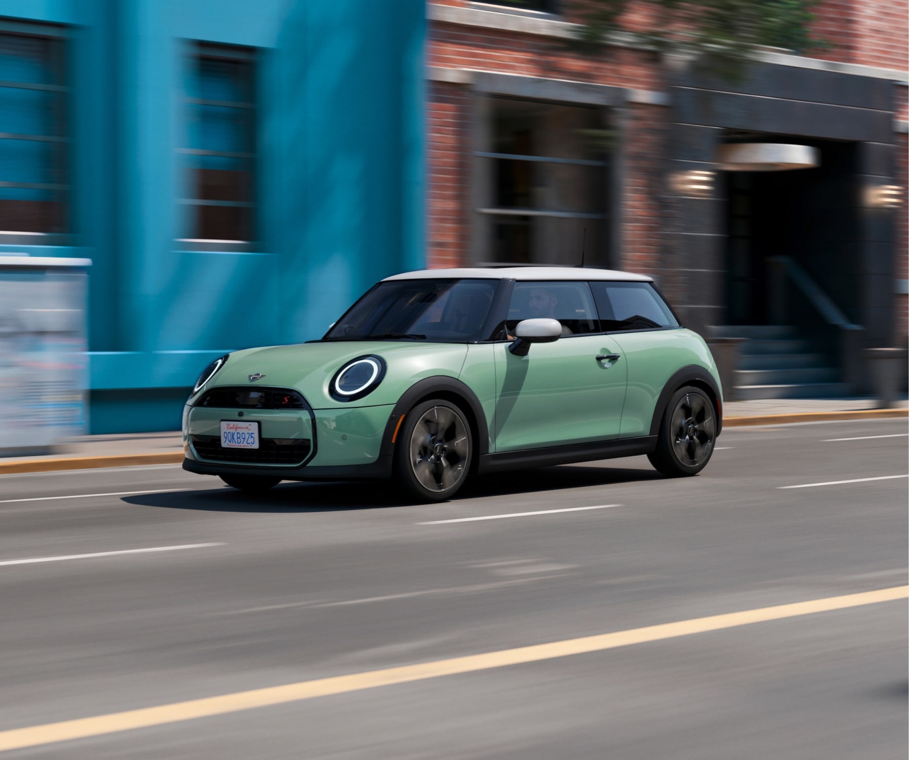 Angled view of a MINI Cooper S 2 Door driving down an urban street.
