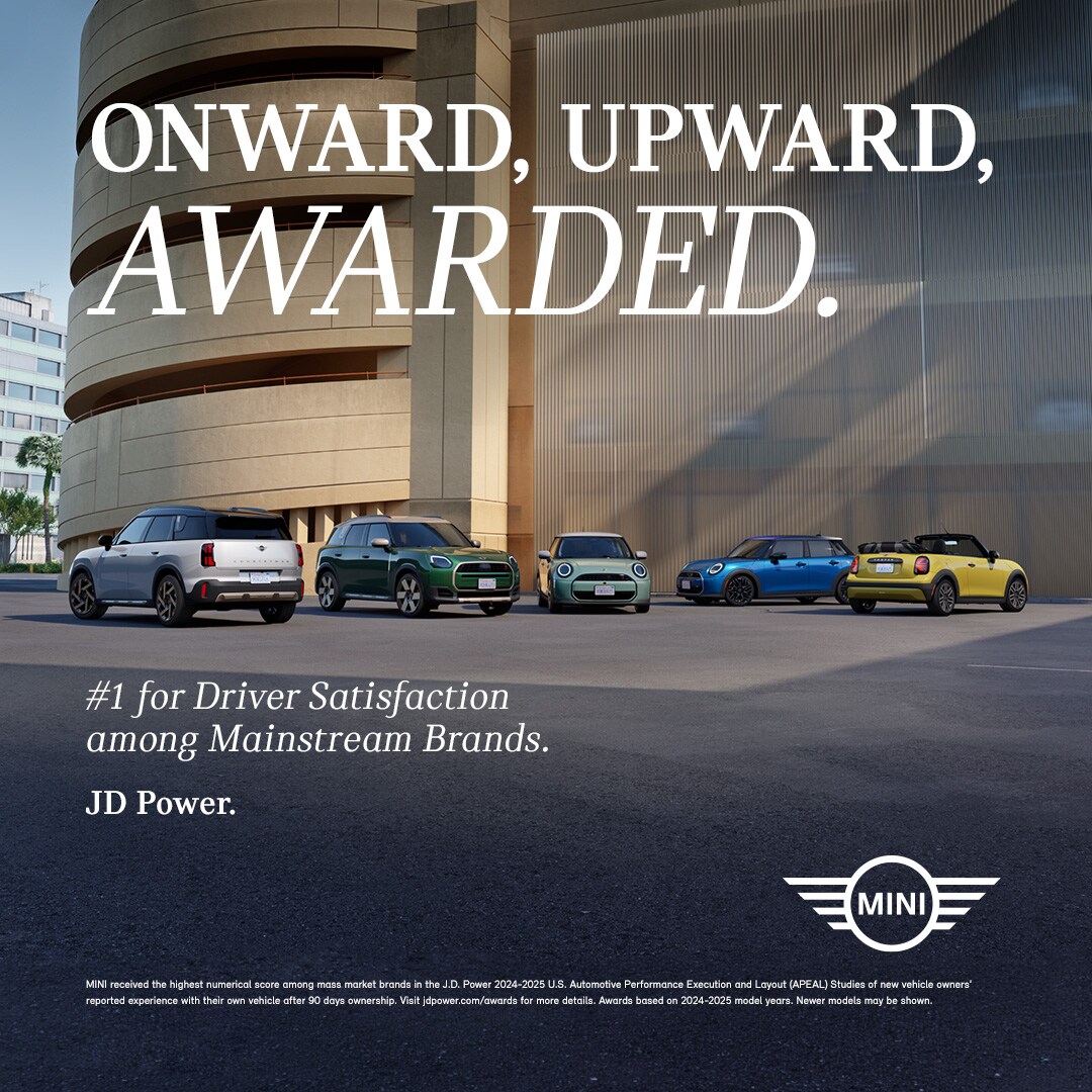 Five different MINI models in different colors parked at different angles in front of a modern building.