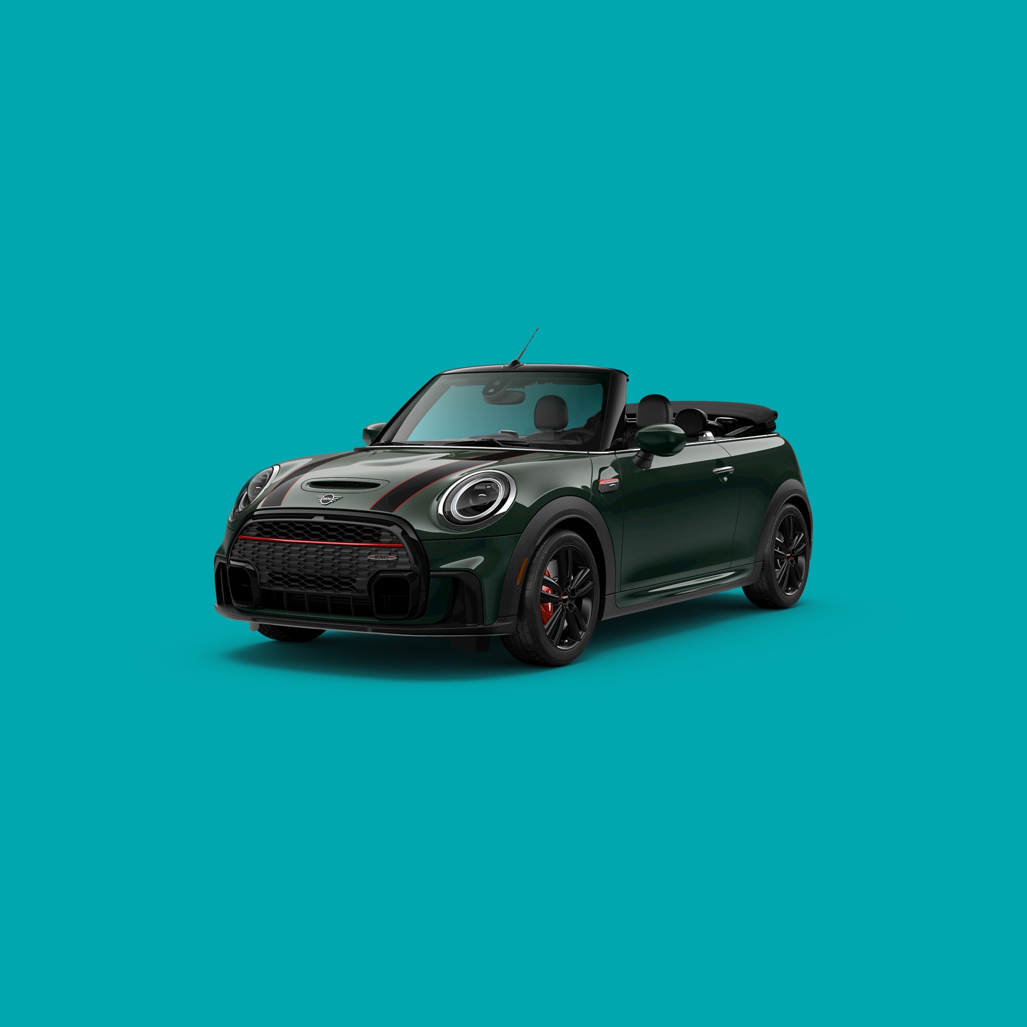 Angled front-to-rear view of a MINI JCW Convertible in John Cooper Works Rebel Green, against a turquoise backdrop.