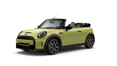 Three-quarters front view of a yellow MINI Convertible parked on a blank surface with its shadow underneath and nothing surrounding it.