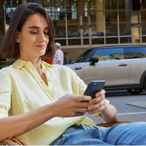 A woman researches MINI oil changes from her phone